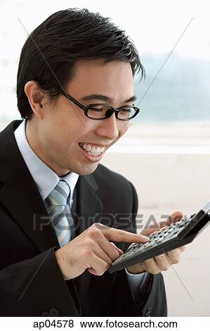 Businessman using calculator, smiling View Large Photo Image Stock Photo - Businessman using calculator, smiling. Fotosearch