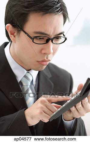 Businessman using calculator View Large Photo Image Stock Photo - Businessman using calculator. Fotosearch