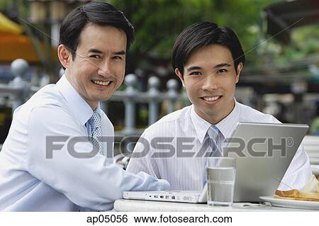 Businessmen at outdoor cafe, smiling at camera View Large Photo Image Stock Photograph - Businessmen at outdoor cafe, smiling at camera. Fotosearch