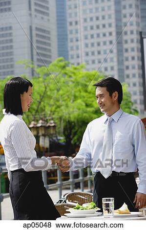 Businesswoman and businessman at outdoor cafe, shaking hands View Large Photo Image Stock Photo - Businesswoman and businessman at outdoor cafe, shaking hands. Fotosearch
