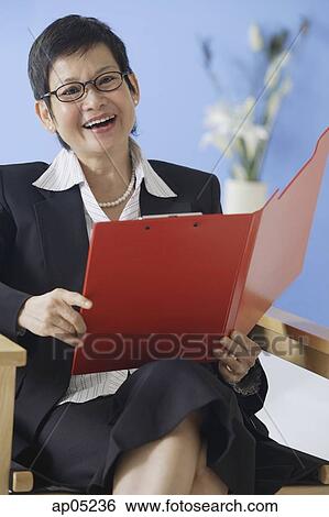 Businesswoman holding clipboard, smiling View Large Photo Image Stock Photograph - Businesswoman holding clipboard, smiling. Fotosearch