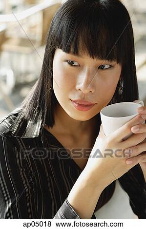 Businesswoman holding cup, looking away View Large Photo Image Stock Photo - Businesswoman holding cup, looking away. Fotosearch