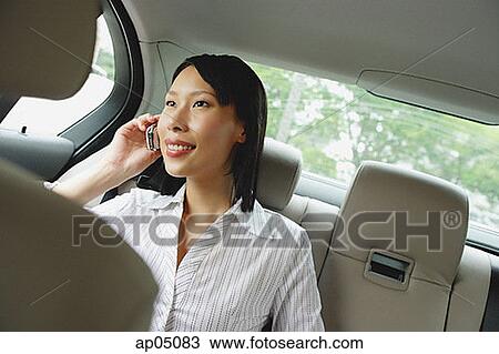 Businesswoman in backseat of car using mobile phone View Large Photo Image Stock Image - Businesswoman in backseat of car using mobile phone. Fotosearch