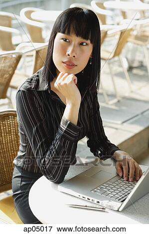 Businesswoman in cafe with laptop, hand on chin, looking away View Large Photo Image Stock Photo - Businesswoman in cafe with laptop, hand on chin, looking away. Fotosearch
