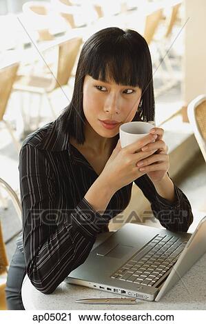 Businesswoman in cafe with laptop, holding cup View Large Photo Image Stock Image - Businesswoman in cafe with laptop, holding cup. Fotosearch