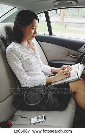 Stock Photo - Businesswoman in car using laptop. Fotosearch
