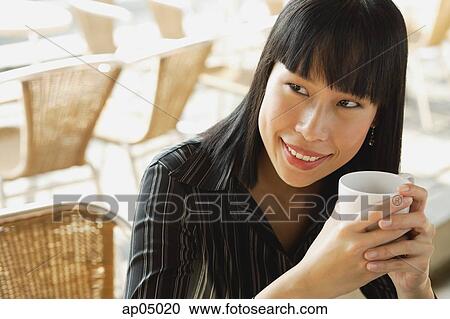 Stock Image - Businesswoman with cup, smiling. Fotosearch