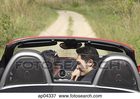 Couple in convertible sports car, looking at each other, rear view View Large Photo Image Stock Photo - Couple in convertible sports car, looking at each other, rear view. Fotosearch