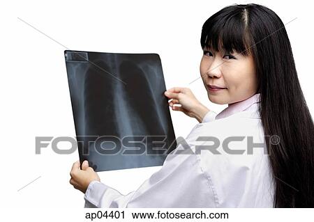 Stock Image - Doctor holding X-ray, looking over shoulder. Fotosearch
