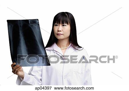 Doctor looking at X-ray View Large Photo Image Stock Photo - Doctor looking at X-ray. Fotosearch