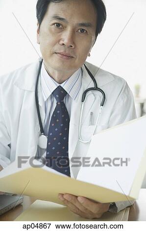 Doctor with folder, looking at camera View Large Photo Image Stock Photo - Doctor with folder, looking at camera. Fotosearch