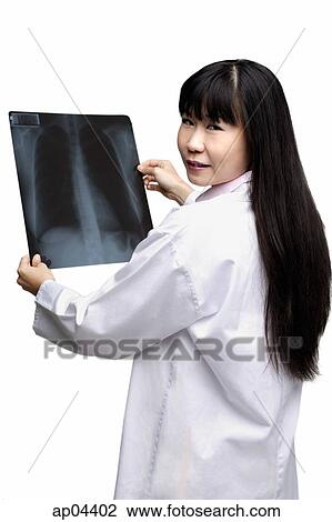Stock Image - Female doctor with X-ray, looking over shoulder. Fotosearch