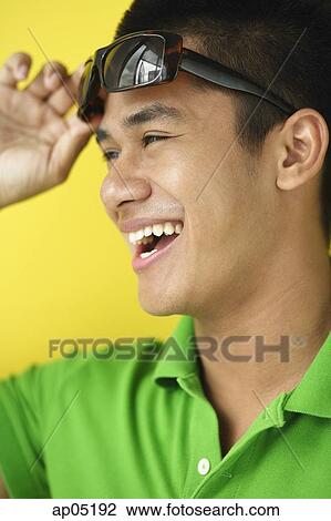 Man adjusting sunglasses, smiling View Large Photo Image Stock Image - Man adjusting sunglasses, smiling. Fotosearch