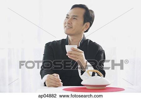 Man drinking tea, looking away View Large Photo Image Stock Image - Man drinking tea, looking away. Fotosearch