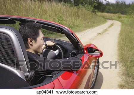 Man driving red convertible sports car along country road View Large Photo Image Stock Image - Man driving red convertible sports car along country road. Fotosearch