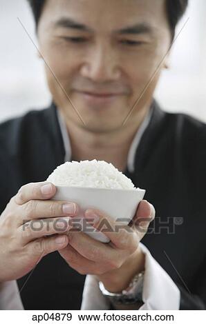 Stock Photo - Man holding bowl of rice. Fotosearch