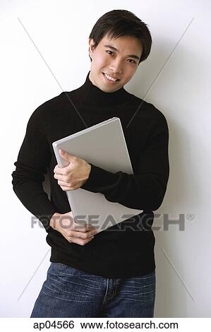Stock Photograph - Man hugging laptop, laughing. Fotosearch