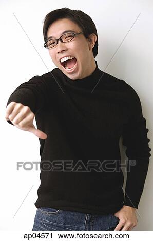 Stock Image - Man in black turtleneck, making thumbs down sign, mouth open. Fotosearch