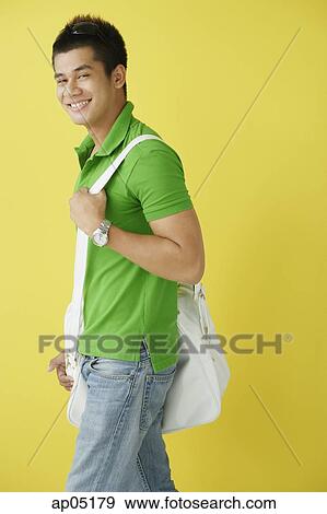 Man in green polo shirt, standing against yellow background, sunglasses on View Large Photo Image Stock Photo - Man in green polo shirt, standing against yellow background, sunglasses on. Fotosearch