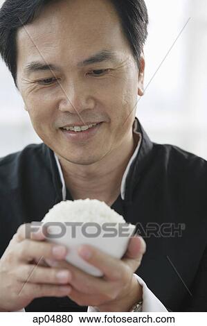 Man looking at bowl of rice in his hands View Large Photo Image Stock Image - Man looking at bowl of rice in his hands. Fotosearch