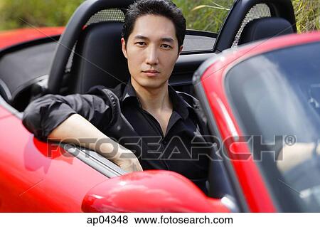 Man sitting in red convertible car, looking at camera, portrait View Large Photo Image Stock Photo - Man sitting in red convertible car, looking at camera, portrait. Fotosearch