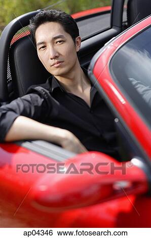 Man sitting in red convertible car, portrait View Large Photo Image Stock Photograph - Man sitting in red convertible car, portrait. Fotosearch