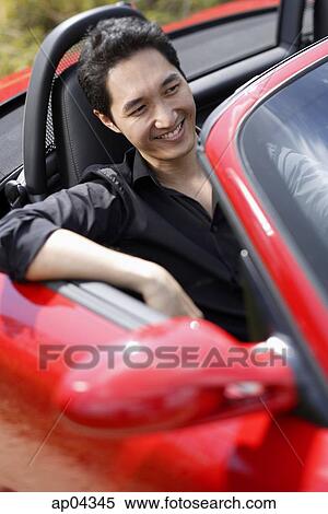 Man sitting in red convertible car, smiling View Large Photo Image Stock Photography - Man sitting in red convertible car, smiling. Fotosearch