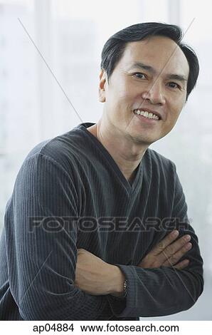 Picture - Man smiling at camera, arms crossed. Fotosearch