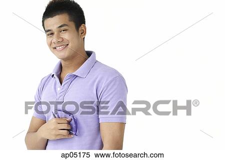 Man smiling at camera, holding sunglasses View Large Photo Image Stock Photography - Man smiling at camera, holding sunglasses. Fotosearch