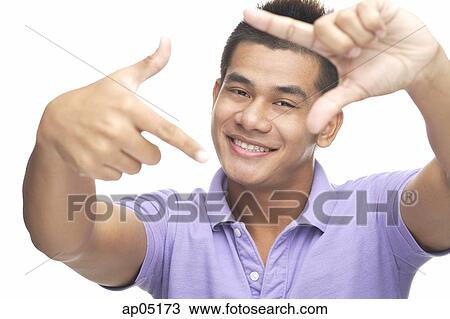 Stock Image - Man smiling at camera, making finger frame. Fotosearch