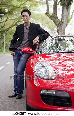 Man standing next to red sports car View Large Photo Image Stock Photo - Man standing next to red sports car. Fotosearch