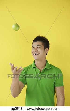 Man tossing green apple View Large Photo Image Picture - Man tossing green apple. Fotosearch
