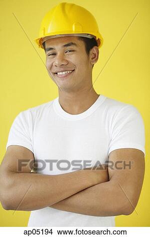 Man wearing hardhat, smiling at camera View Large Photo Image Picture - Man wearing hardhat, smiling at camera. Fotosearch