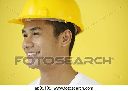 Stock Photography - Man wearing hardhat, smiling, head shot. Fotosearch