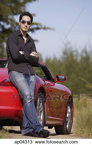 Man wearing sunglasses, arms crossed, leaning on red sports car View Large Photo Image Stock Image - Man wearing sunglasses, arms crossed, leaning on red sports car. Fotosearch