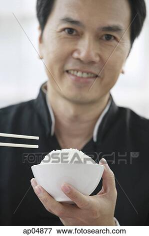 Stock Photo - Man with bowl of rice and chopsticks. Fotosearch
