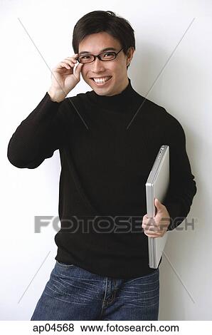 Man with laptop, adjusting glasses View Large Photo Image Stock Photo - Man with laptop, adjusting glasses. Fotosearch