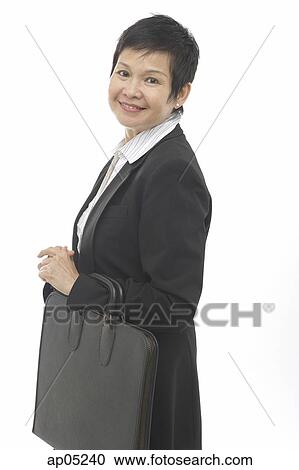 Mature businesswoman, carrying briefcase, smiling at camera View Large Photo Image Stock Image - Mature businesswoman, carrying briefcase, smiling at camera. Fotosearch