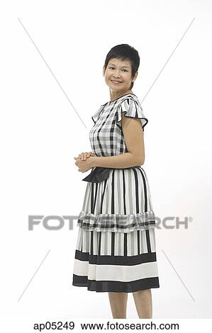 Stock Photo - Mature woman against white background, smiling at camera. Fotosearch
