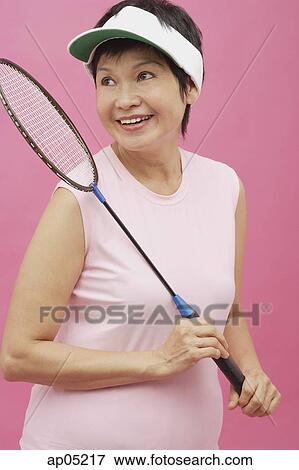 Stock Photo - Mature woman holding badminton racket. Fotosearch