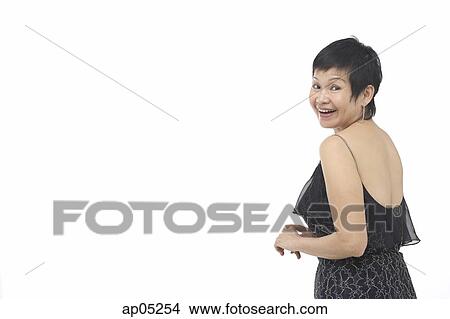 Mature woman in black dress, looking over shoulder View Large Photo Image Picture - Mature woman in black dress, looking over shoulder. Fotosearch