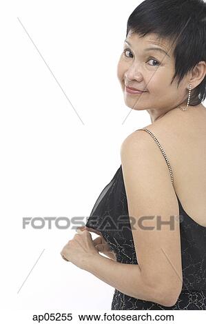 Stock Photography - Mature woman in black sleeveless top, looking over shoulder. Fotosearch