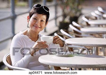 Mature woman in cafe having a drink View Large Photo Image Stock Image - Mature woman in cafe having a drink. Fotosearch