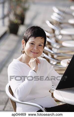 Mature woman in cafe, holding a menu View Large Photo Image Stock Photo - Mature woman in cafe, holding a menu. Fotosearch