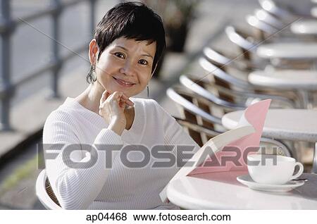 Mature woman in cafe, reading a book View Large Photo Image Stock Photo - Mature woman in cafe, reading a book. Fotosearch