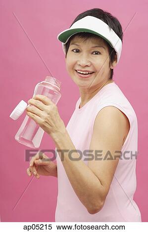 Mature woman wearing sun visor and water bottle View Large Photo Image Stock Photography - Mature woman wearing sun visor and water bottle. Fotosearch