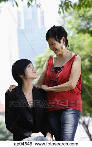 Stock Photograph - Mother and adult daughter looking at each other. Fotosearch