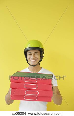 Pizza delivery person carrying a stack of pizza boxes View Large Photo Image Picture - Pizza delivery person carrying a stack of pizza boxes. Fotosearch