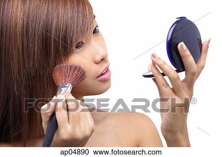 Teenage girl applying make-up, looking at compact View Large Photo Image Stock Image - Teenage girl applying make-up, looking at compact. Fotosearch