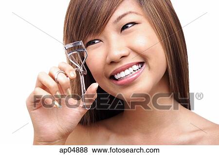 Teenage girl using eyelash curler, looking away View Large Photo Image Stock Photo - Teenage girl using eyelash curler, looking away. Fotosearch